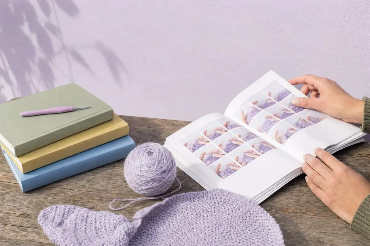 A stack of crochet books, one opened to step-by-step photos
